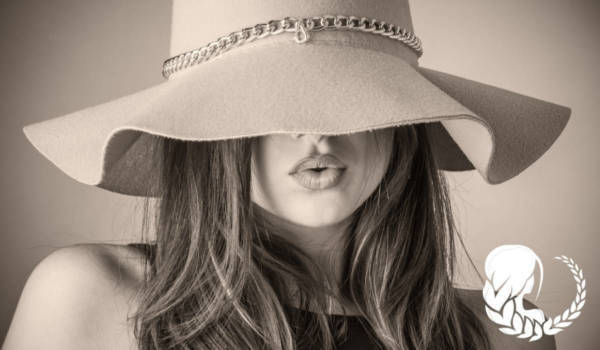 Γυναίκα που κρύβει το πρόσωπό της με ένα καπέλο